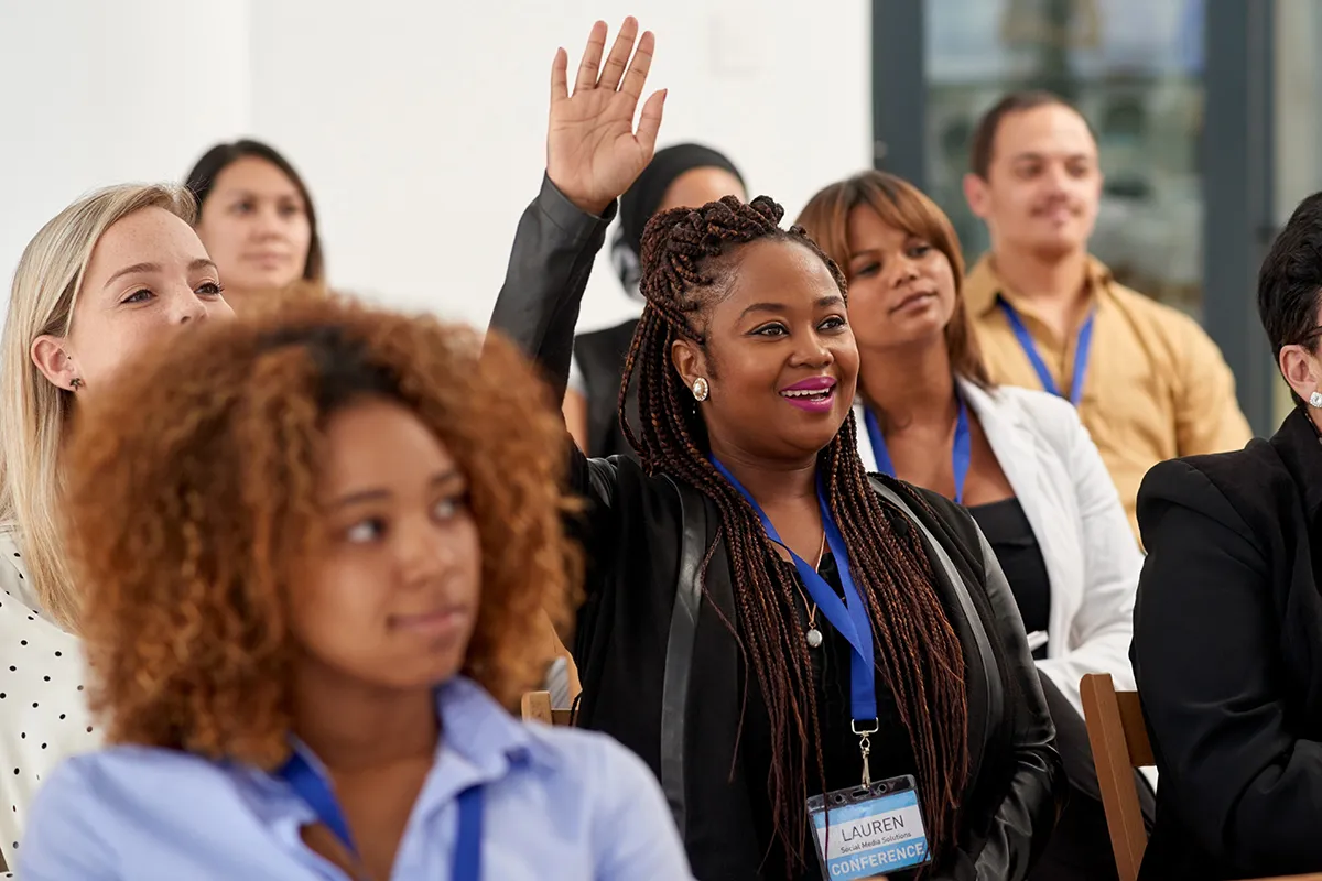 Woman raising her hand during a training conference.