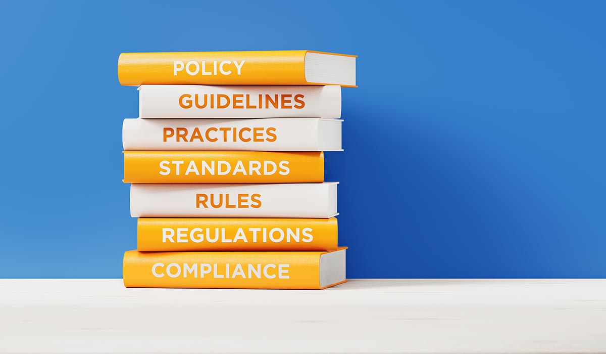 Books with different compliance and regulation titles.